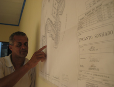 Funcionário da imobiliária Amilson Seabra, em Minaçu, mostra o mapa de um loteamento próximo ao lago de Cana Brava