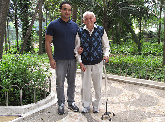 Jos Fraso,o, 89,caminha em seu condomnio com auxlio de seu cuidador, o tcnico de enfermagem Cristiano , 25 