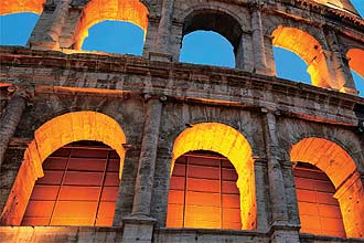  noite, o Coliseu ganha relevo sob o efeito de luzes amareladas; monumento histrico relembra a antiga Roma dos imperadores