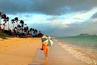 Mulher com guarda-chuva na praia de Lanikai, no Havaí (EUA); número de turistas na ilha cresceu 10% de janeiro a setembro