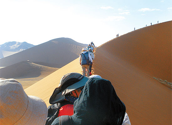 Na Nambia, grupo de turistas faz passeio sobre duna na regio do deserto de Sossusvlei