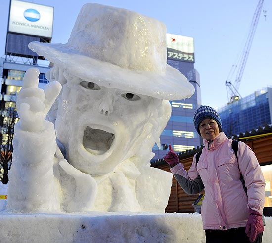 Turista posa ao lado de esttua de gelo do cantor Michael Jackson em Sapporo, local do festival da neve