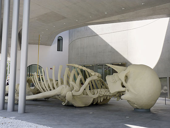 ROM03. ROMA (ITALIA), 27/05/2010.- "Cosmic Magnet", el esqueleto gigante de 24 metros de longitud que el artista italiano Gino de Dominicis (Roma, 1947-Ancona, 1998) realiz poco antes de morir, da la bienvenida a los visitantes desde el jardn de entrada en el exterior del Museo Nacional para las Artes del Siglo XXI (MAXXI) de Roma, diseado por la prestigiosa arquitecta anglo-iraqu Zaha Hadid, que se ha inaugurado hoy. Esta es la primera de las 130 obras del artista italiano que componen la muestra "L'Immortale", hasta el 7 de noviembre. EFE/Carmen Pliego