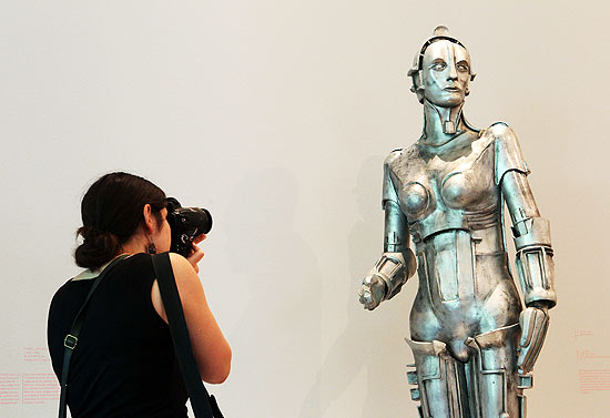 A woman takes a picture of a replica of the humanoid Maria of the movie 'Metropolis' from 1927 by German director Fritz Lang during a media preview of the exhibition 'Robot Dreams' at the Museum Tinguely in Basel June 8, 2010. The exhibition is opened to the public from June 9 to September 9, 2010. REUTERS/Arnd Wiegmann (SWITZERLAND - Tags: ENTERTAINMENT)
