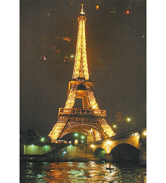 Em imagem noturna, a Torre Eiffel vista de barco turístico ( www.bateauxparisiens.com)