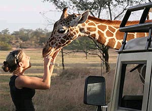 Turista com girafa em zoológico na Costa Rica