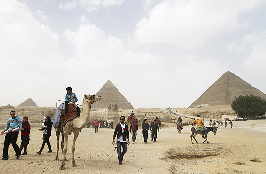 Alguns dos poucos turistas passeando pelas Pirâmides de Gizé neste domingo (20)