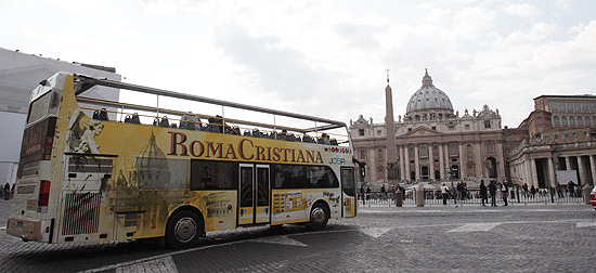 Ônibus de turismo passa pela praça de São Pedro, Vaticano, onde será a missa de beatificação de João Paulo 2º