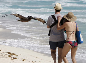 Casal caminha pela praia Marlin, em Cancun, no Mxico