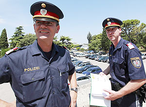Policiais austríacos Johann Zsifkovits (esq.) e Mirco Durinovic patrulham a cidade de Pula, no norte do mar Adriático