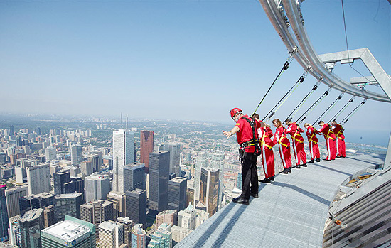 Visitantes se debruam no parapeito da CN Tower, em Toronto