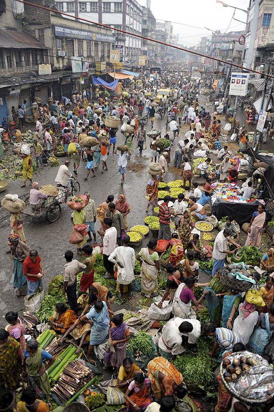 Comerciantes indianos negociam produtos em mercado de rua em Calcutá