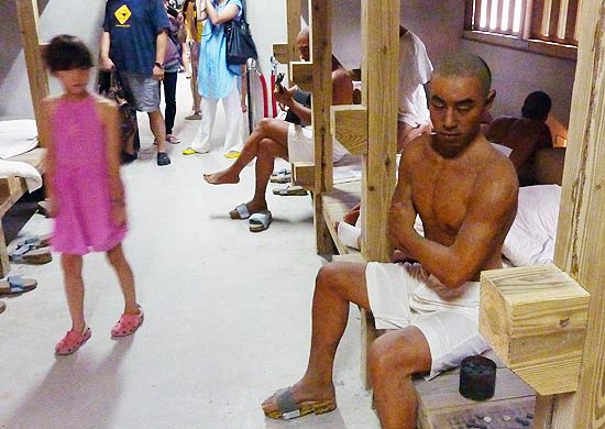 Visitantes observam dormitório-prisão habitado por "prisioneiros" feitos de cera, em Green Island, ilha de Taiwan
