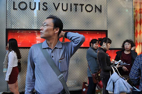 Turista chinês diante de loja da Louis Vuitton, em Hong Kong; mercado do luxo mira asiáticos, que representam 17% das vendas