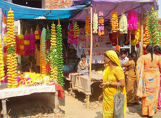 Indianos passeiam por mercado em rua de Déli