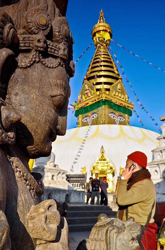 Monge budista fala ao celular no templo Swayambhunath, em Katmandu, capital do Nepal  ponto de partida para aventureiros rumo ao Himalaia