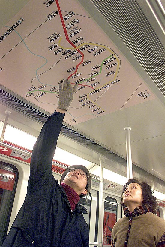 Usuários consultam mapa de metrô de Xangai dentro de trem