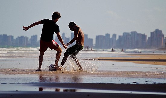 Garotos jogam bola na praia de Boa Viagem em Recife (PE)