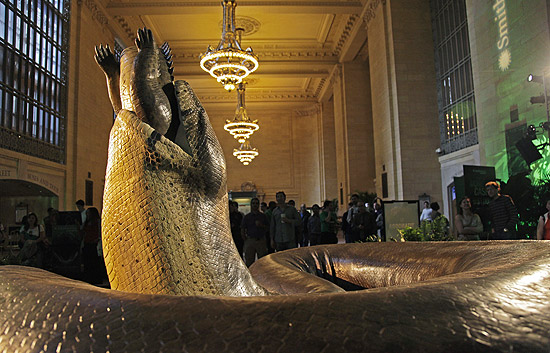 Réplica de serpente pré-histórica engolindo um crocodilo, em exibição na estação Grand Central, em Nova York