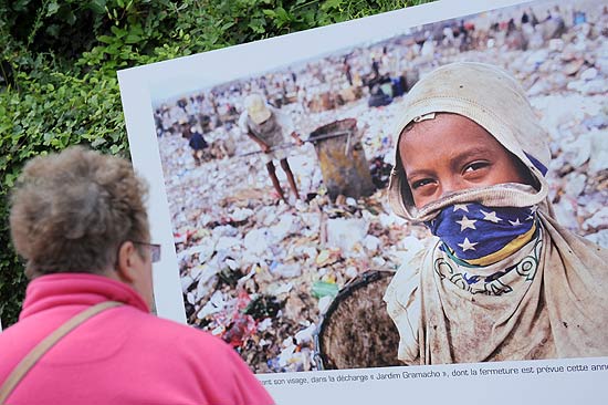 Mulher observa fotografia da agência brasileira Tyba exposta no festival "Povos e natureza" 
