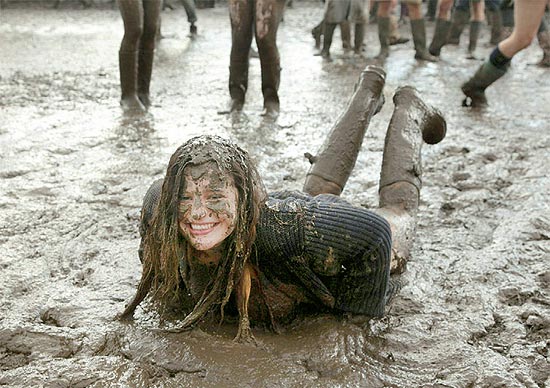Garota se diverte na lama no festival de Reading, que traz Kasabian e The Cure neste ano