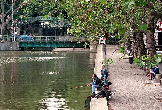 Parisienses pescam ao longo do canal Saint Martin, em Paris 