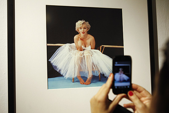 Mulher tira fotografia de imagem da atriz Marilyn Monroe em exposio em Varsvia, na Polnia
