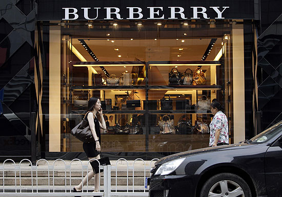 Mulheres passam por vitrine de loja da grife Burberry em Pequim, na China