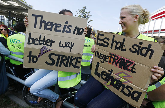 Funcionrias da Lufthansa carregam cartazes com dizeres de apoio  greve de comissrios de bordo da companhia