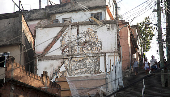 Moradores do Morro da Providência perto de obra do português Vhils; ele pintou rostos de habitantes locais