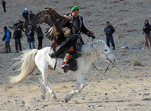 Homem durante competição de águias em Olgii