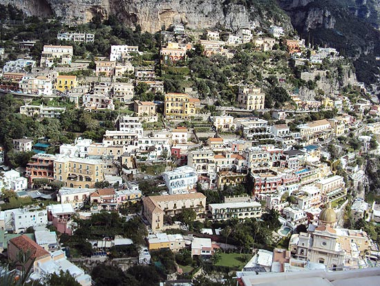 Vista de casas de Positano, que fica espremida entre duas montanhas e exibe praia; regio atrai brasileiros