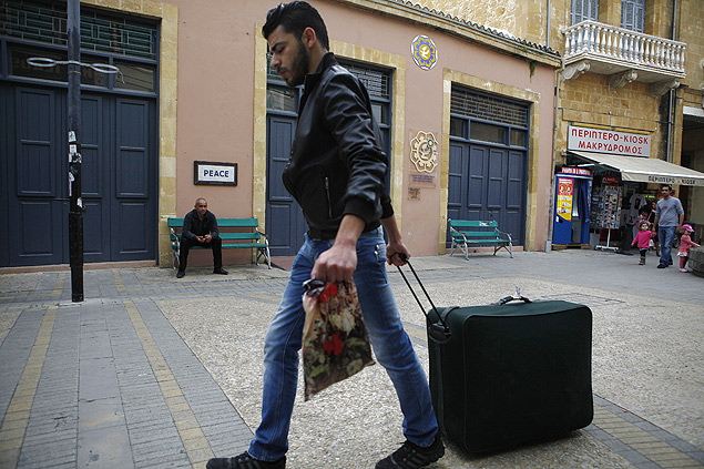 Homem carrega mala em rua de Nicsia, capital de Chipre; pas teme que crise afugente turistas