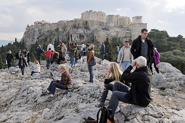 Turistas observam a Acrpole de Atenas a partir de uma colina; sito arqueolgico ficou fechado em dezembro passado devido a uma greve