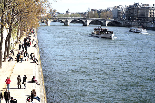 Parisienses e turistas aproveitam o dia de sol s margens do rio Sena