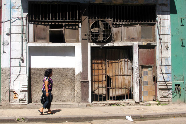 Mulher passa em frente a casa de Havana Vieja