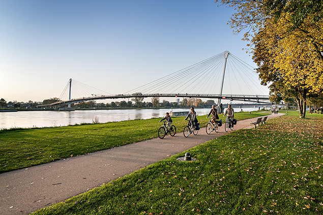 Ciclistas passam ao lado do rio Reno, na Alemanha
