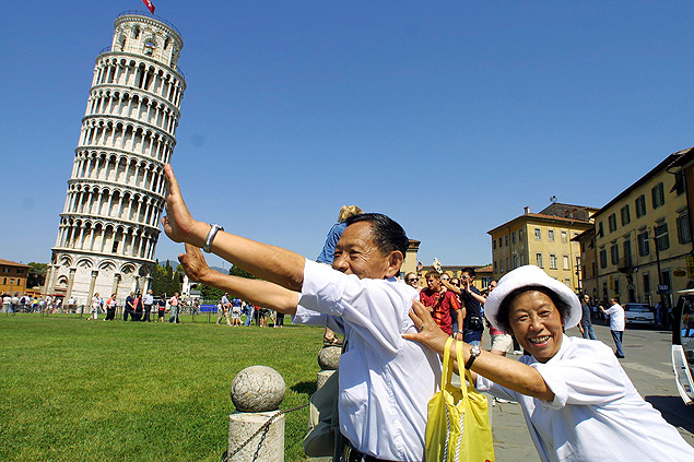 ORG XMIT: 434301_1.tif Turistas chineses fazem pose em frente  Torre de Pisa, na Itlia. Two unidentified Chinese tourists pretend to hold up the leaning tower of Pisa, in central Italy, the day before the official opening ceremony marking the end of restoration on Friday, June 15, 2001. The work to partially straighten the famous tilted monument began 10 years ago when the tower leaned 6 degrees, or 13 feet, off the perpendicular on its south side. By removing a small amount of soil, and using steel cables known as 