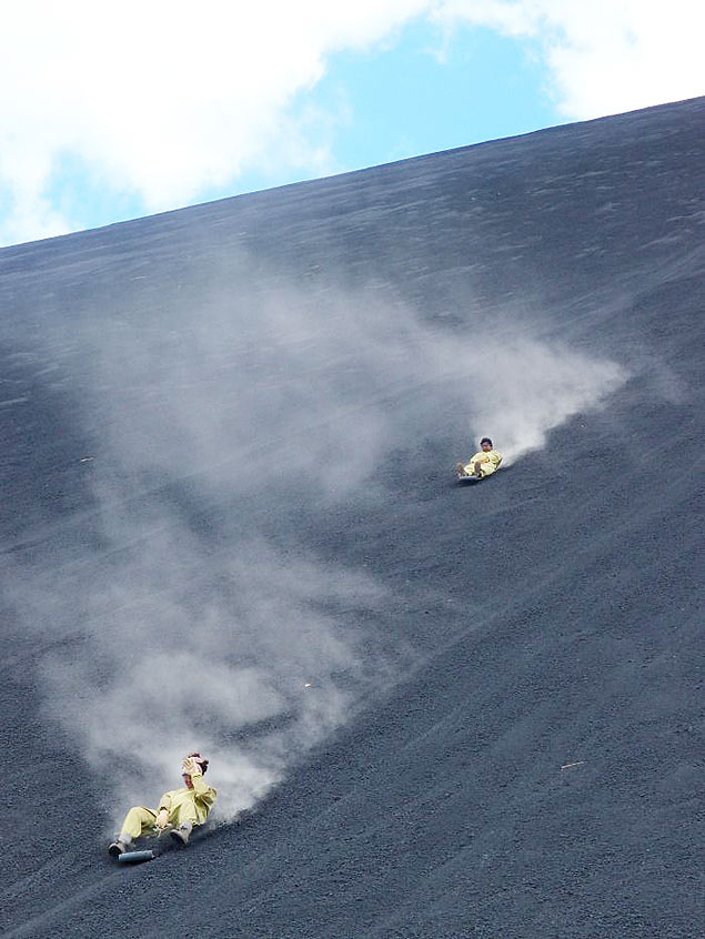Turistas praticam "volcano boarding", ou surfe em vulco, no Cerro Negro na Nicargua 