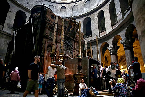 Turistas na igreja do Santo Sepulcro em fila sob estrutura instalada para as reformas