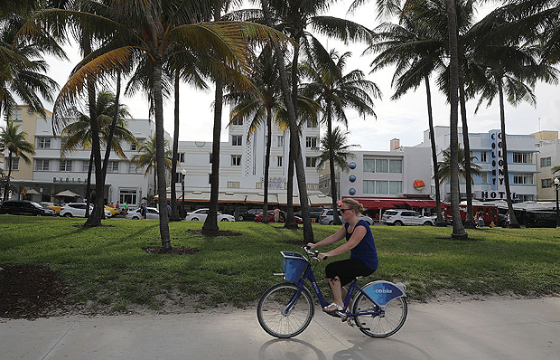MIAMI BEACH, FL - MAY 16: A woman rides a bike along South Beach on May 16, 2016 in Miami Beach, Florida. The Florida government announced the state broke a tourism record in the first quarter of this year, attracting 29.8 million tourists, an increase of 4.8 percent over the same time frame in 2015. Joe Raedle/Getty Images/AFP == FOR NEWSPAPERS, INTERNET, TELCOS & TELEVISION USE ONLY ==