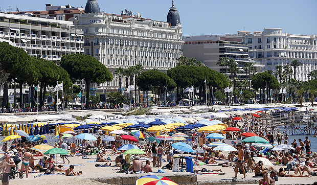 People take a sunbath on the beach in the French southeastern city of Cannes on July 31, 2013. AFP PHOTO / VALERY HACHE ORG XMIT: VH2845