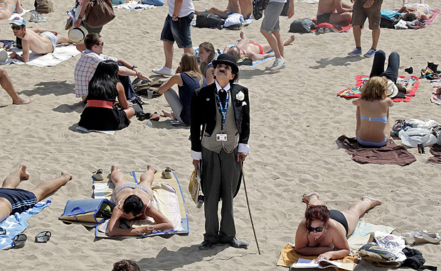 ORG XMIT: CAN343 A man dressed as Charlie Chaplin walks on the beach in Cannes during the 65th Cannes Film Festival May 17, 2012. REUTERS/Eric Gaillard (FRANCE - Tags: ENTERTAINMENT)