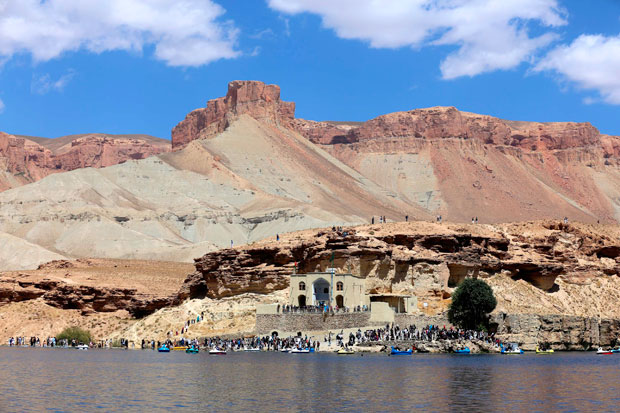 Afghan tourists are pictured at the water's edge of the Band-e Amir lake on the outskirts of Bamiyan on August 29, 2014. Bamiyan, some 200 kilometres (124 miles) northwest of Kabul, stands in a deep green and lush valley stretching 100 kilometres through central Afghanistan, on the former Silk Road that once linked China with Central Asia and beyond. The town was home to two nearly 2,000-year-old Buddha statues before they were destroyed by the Taliban, months before their regime was toppled in a US-led invasion in late 2001. AFP PHOTO/Kamran SHEFAYEE ORG XMIT: WK2454