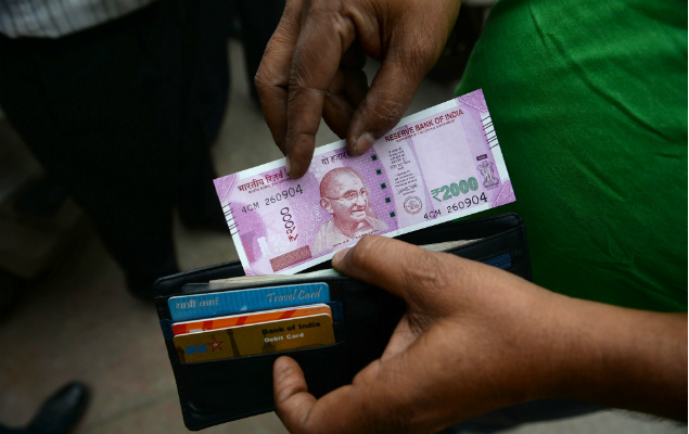Indiano guarda dinheiro em sua carteira