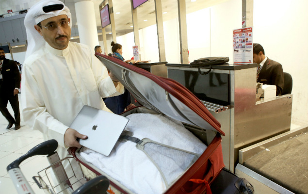 Thamer al-Dakheel Bourashed coloca seu notebook dentro da mala despachada no aeroporto do Kuwait 