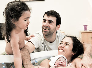 Marcelly, o marido André e a filha Olívia após o nascimento de Inácio em casa