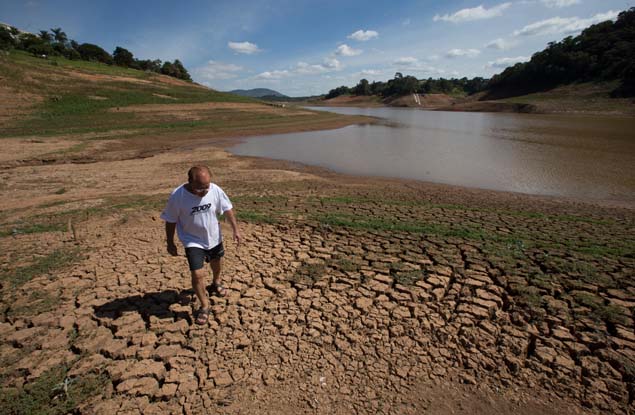 Homem caminha em trecho seco de rio que abastece o sistema Cantareira na Grande So Paulo