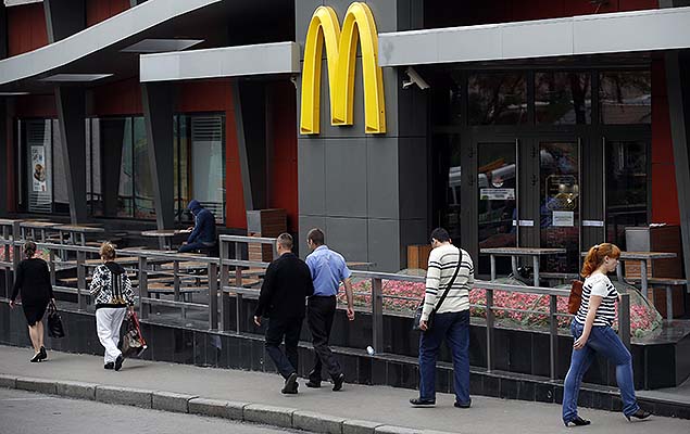 Pessoas passam em frente a loja fechada do McDonalds em Moscou