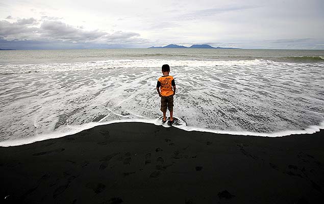 HOT01 BANDA ACEH (INDONESIA) 26/12/2014.- Un nio camina por la orilla en la playa Syiah en Indonesia durante el dcimo aniversario del tsunami hoy, viernes 26 de diciembre de 2014. Miles de personas participaron en Indonesia en una plegaria de recuerdo a las vctimas del tsunami que hoy hace 10 aos caus 230.000 muertos en el ocano ndico, en el inicio a los actos de conmemoracin que tendrn lugar en toda la regin.